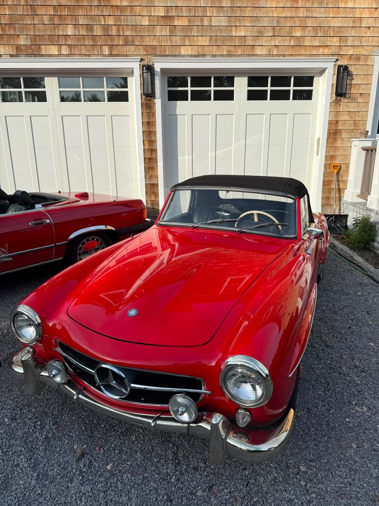 A vintage red Mercedes-Benz convertible parked in the driveway before The Art Affair