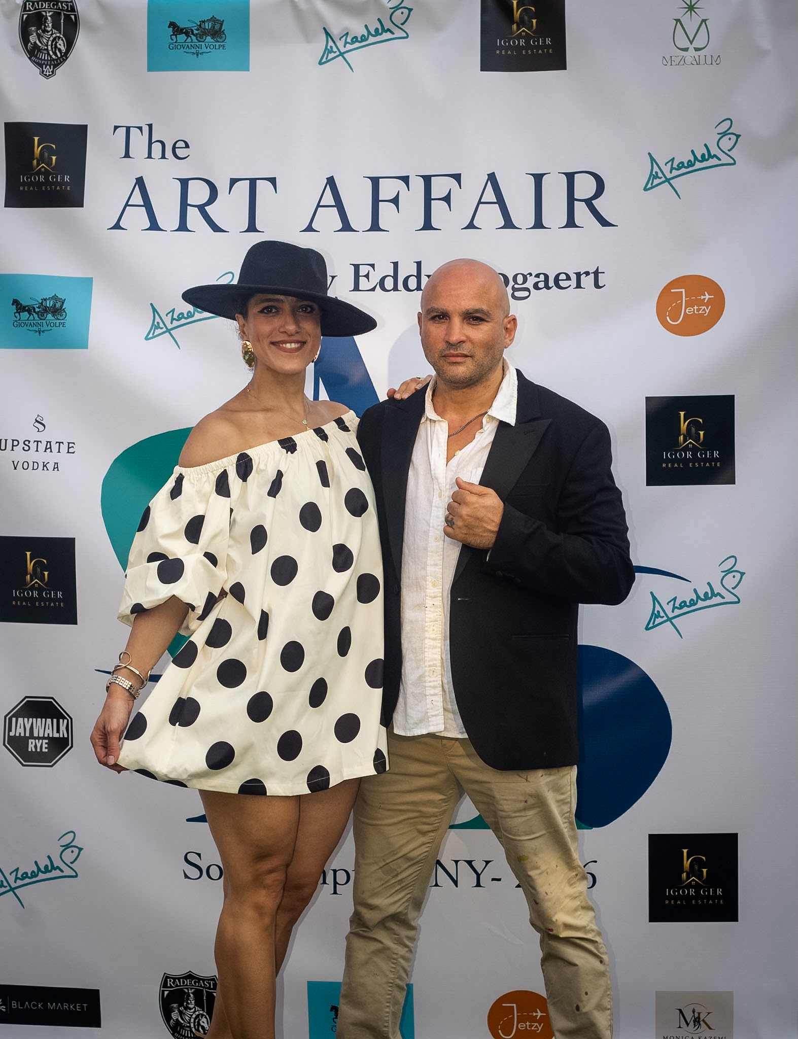 Eddy Bogaert and a guest pose at The Art Affair step-and-repeat in Southampton