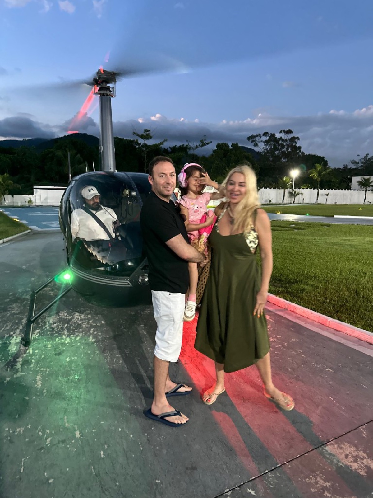 Mike and family beside a helicopter at dusk