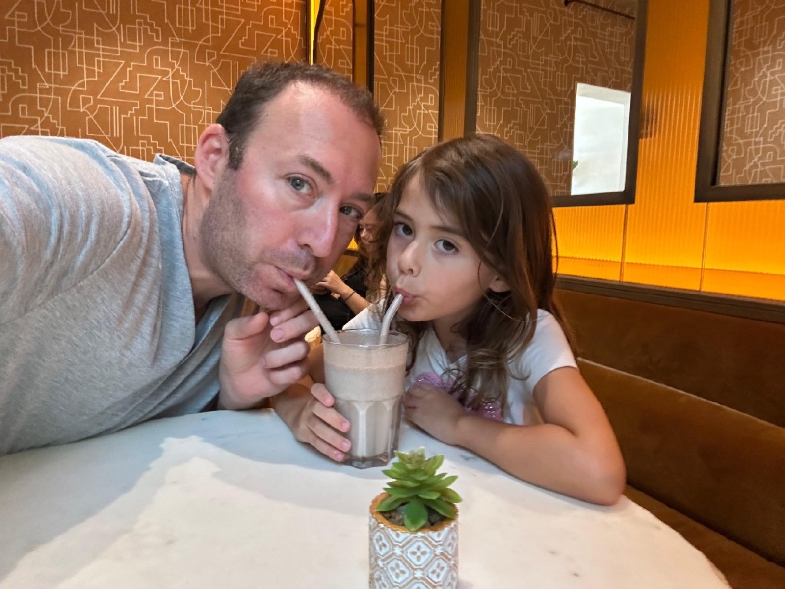 Mike and Billie sharing a milkshake