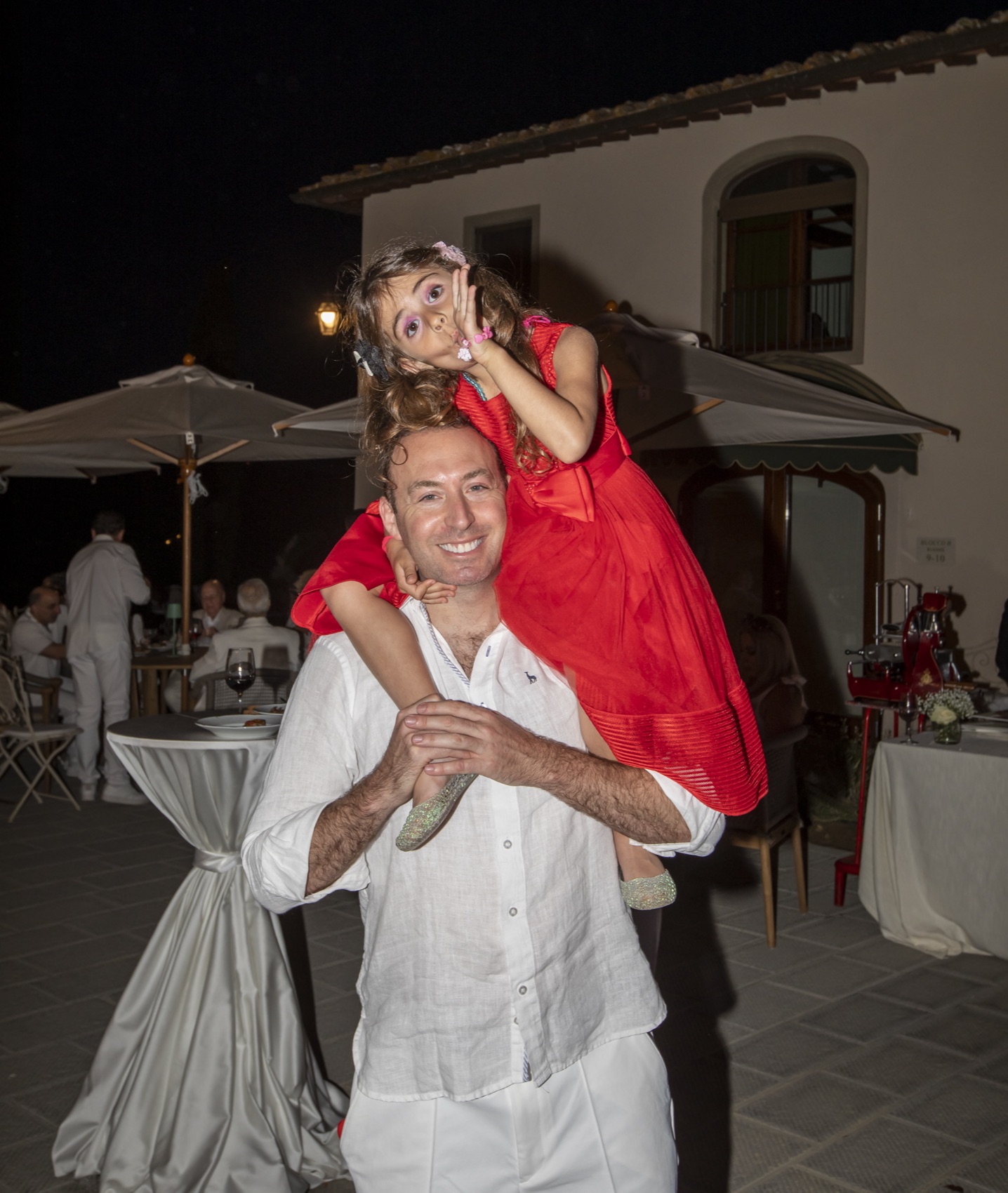 Mike carrying his daughter on his shoulders at the villa in the evening