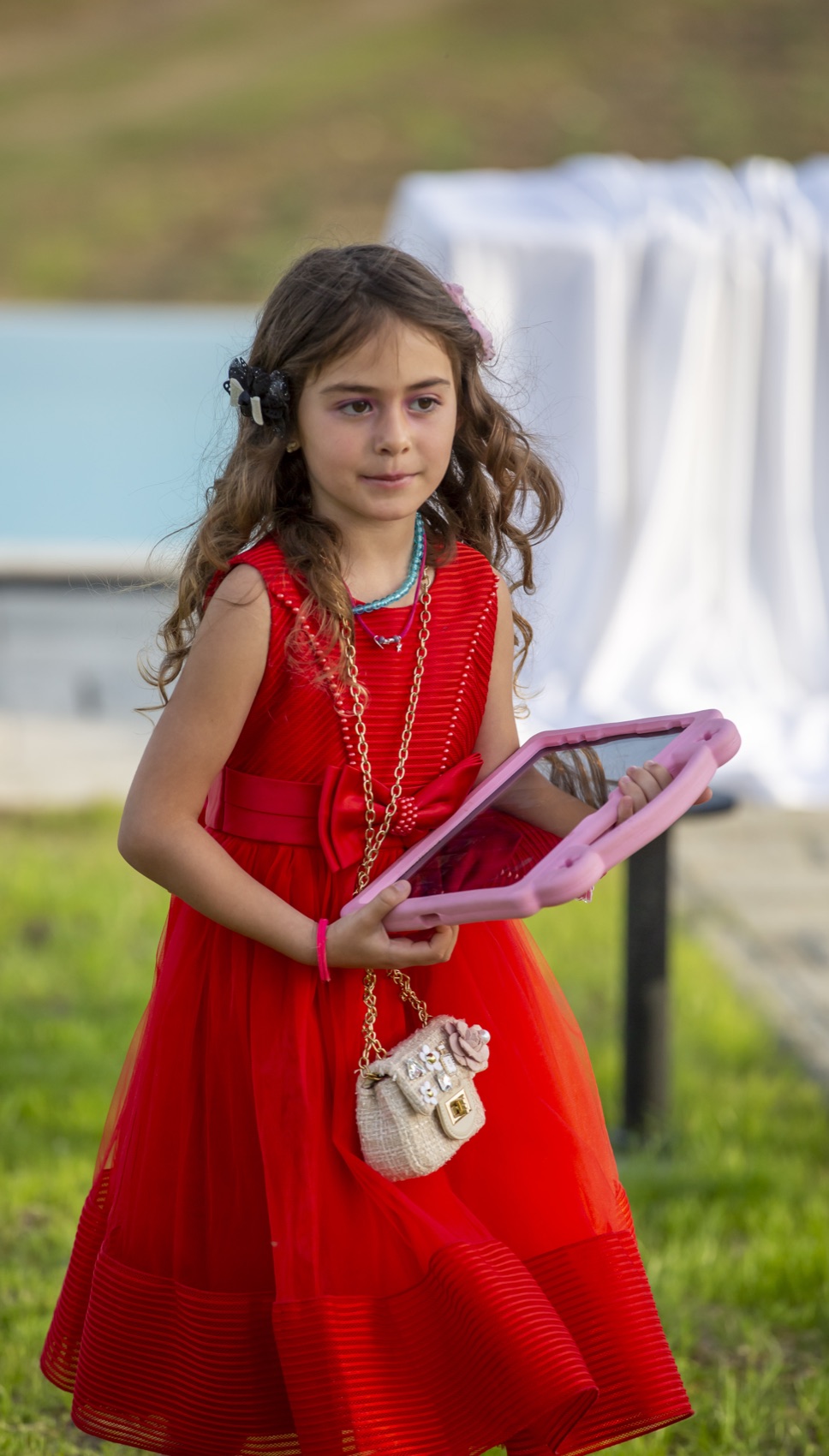 Mike's daughter in a red dress on the villa lawn